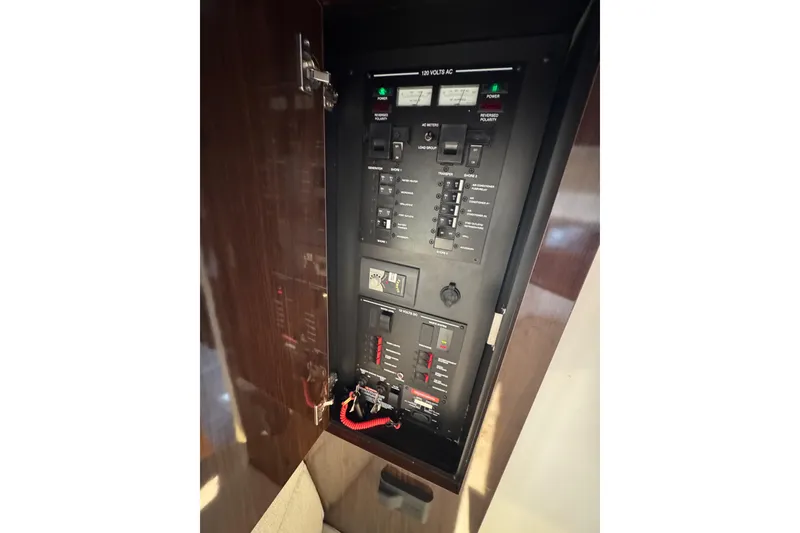 Slide: The Image of Electrical panel inside 2019 Sea Ray Sundancer 320 yacht, showcasing circuit breakers and controls. - 53