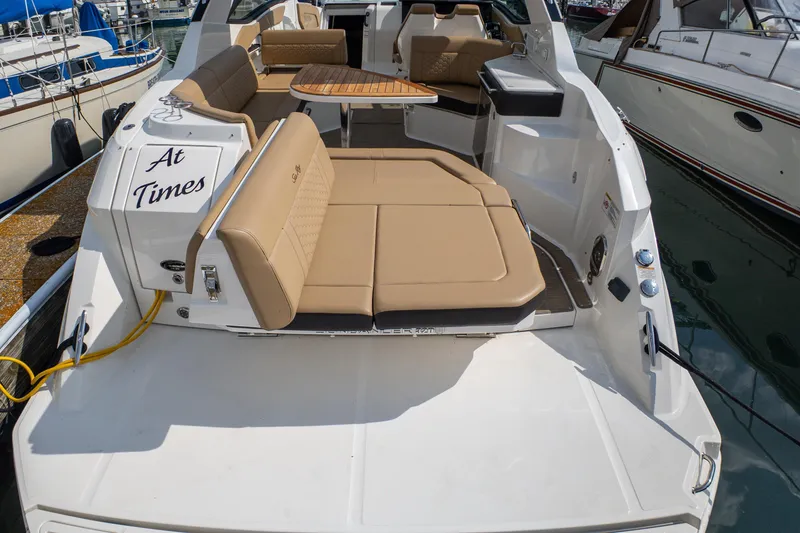 Slide: The Image of 2019 Sea Ray Sundancer 320 yacht with tan seating and wooden table at marina. - 8