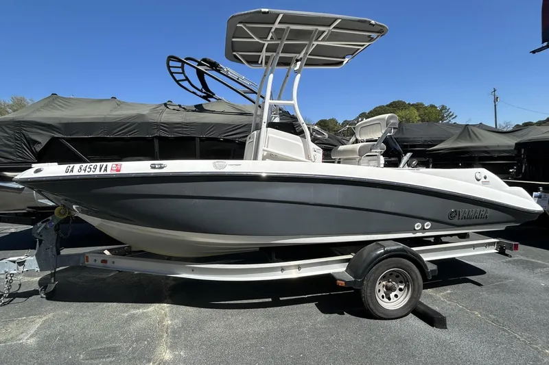 The Image of 2016 Yamaha Boats 190 FSH Sport on trailer, parked outdoors under clear sky. - 1