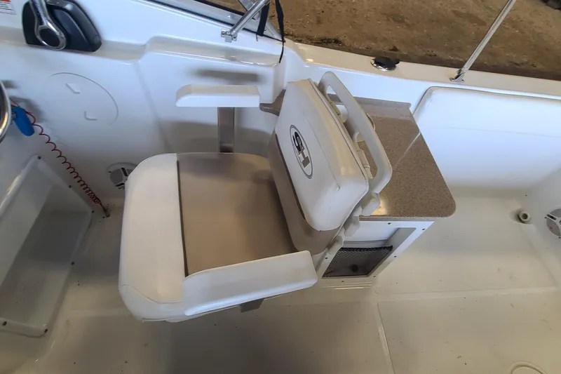 Slide: The Image of Captain's chair on 2013 Sea Hunt Escape 234 LE boat, featuring white upholstery and armrests. - 15