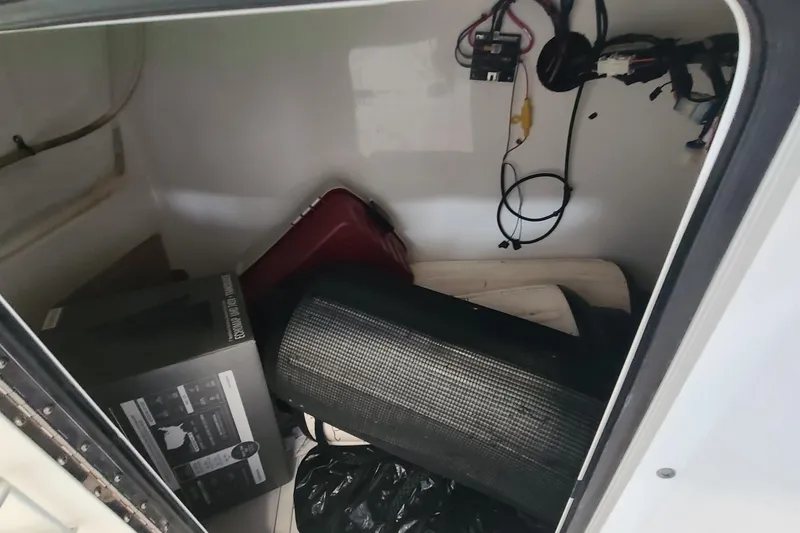 Slide: The Image of Storage compartment of a 2013 Sea Hunt Escape 234 LE boat with various items inside. - 18