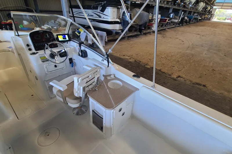 Slide: The Image of 2013 Sea Hunt Escape 234 LE boat interior with steering wheel and control panel. - 22