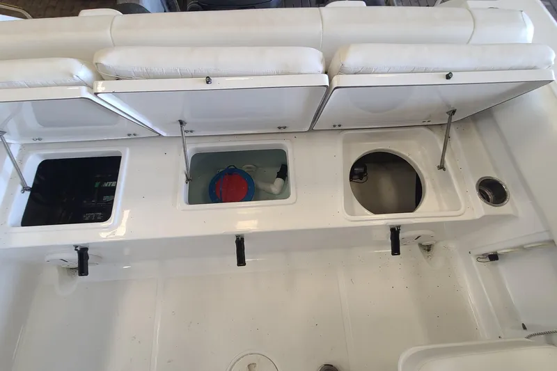 Slide: The Image of 2013 Sea Hunt Escape 234 LE boat interior with open storage compartments and seating. - 25