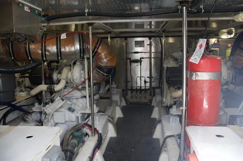 Slide: The Image of Engine room of a 2002 McKinna 57 Pilothouse yacht, featuring machinery and fire extinguisher. - 33
