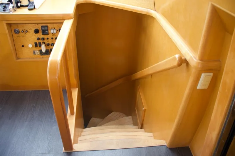 Slide: The Image of Staircase inside 2002 McKinna 57 Pilothouse yacht with wooden handrails and control panel. - 50