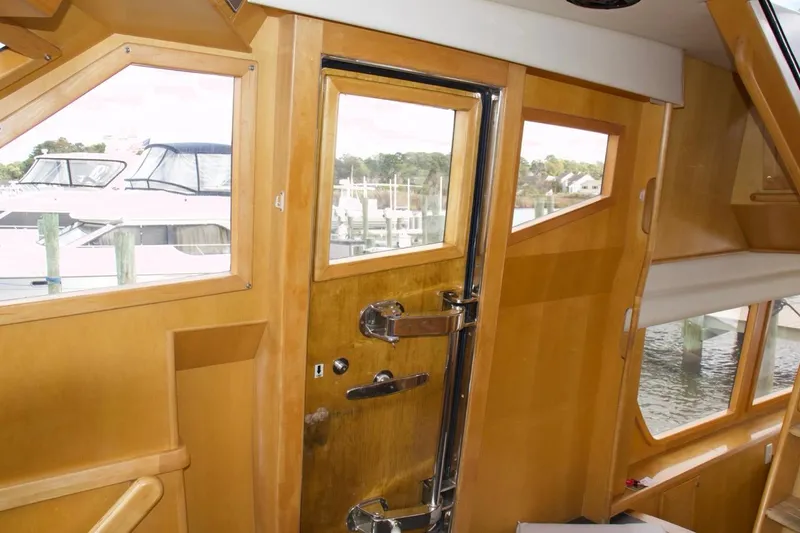 Slide: The Image of Interior view of 2002 McKinna 57 Pilothouse yacht with wooden finish and dockside scenery. - 51