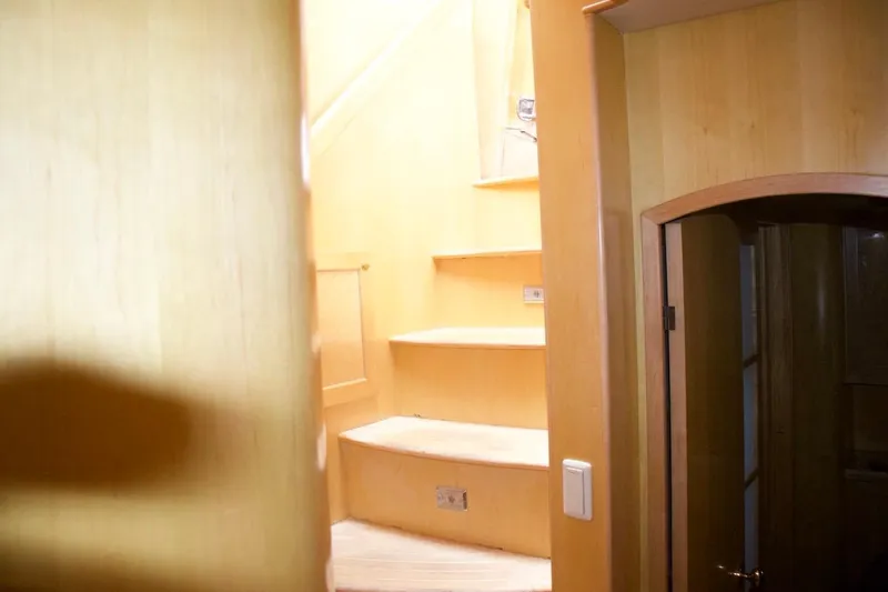 Slide: The Image of Interior staircase of 2002 McKinna 57 Pilothouse yacht, featuring wooden steps and walls. - 53