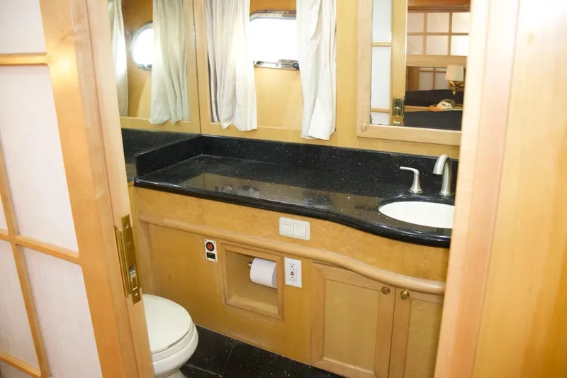 Slide: The Image of Luxurious bathroom in 2002 McKinna 57 Pilothouse yacht with sleek black countertop. - 58