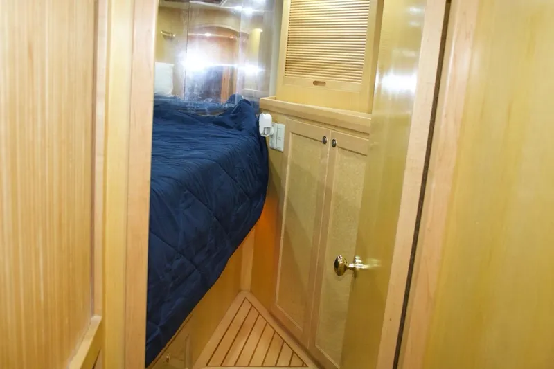 Slide: The Image of Interior cabin of 2002 McKinna 57 Pilothouse with wooden paneling and blue bedding. - 63
