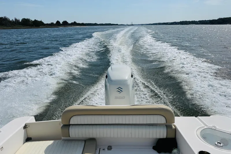 Slide: The Image of 2018 Sea Born LX24 Center Console boat cruising on open water, leaving a wake. - 12