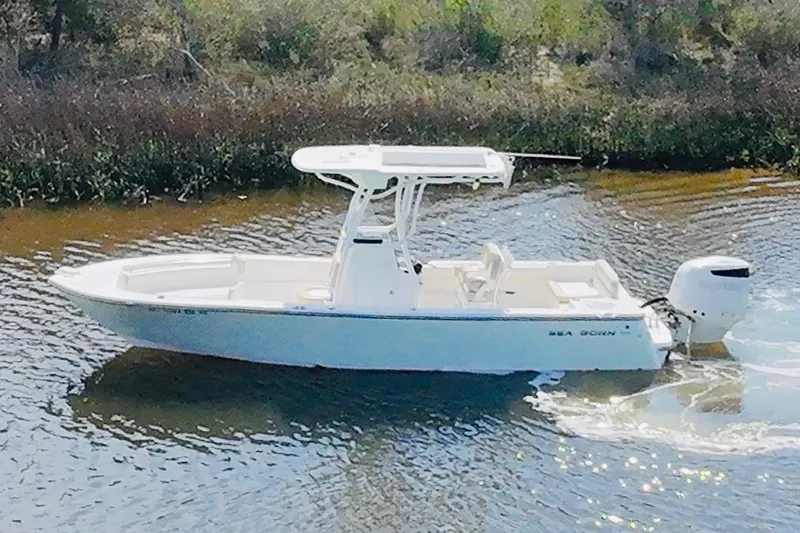 Slide: The Image of 2018 Sea Born LX24 Center Console boat cruising on a calm waterway. - 18