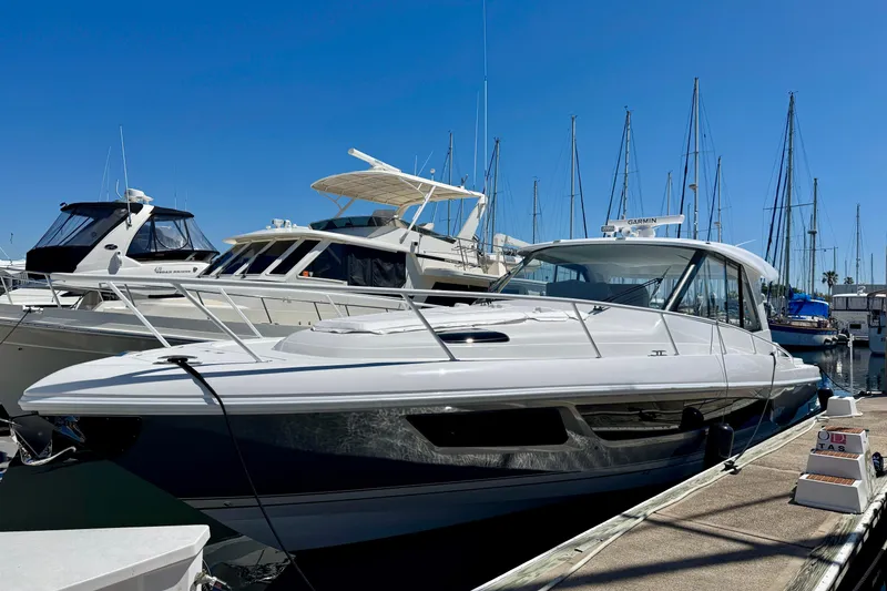 Slide: The Image of 2025 Intrepid 50 Evolution yacht docked at marina under clear blue sky. - 1