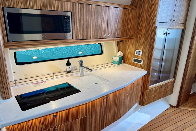 Slide: The Image of Modern kitchen interior of 2025 Intrepid 50 Evolution yacht with wood finish and ocean view. - 29