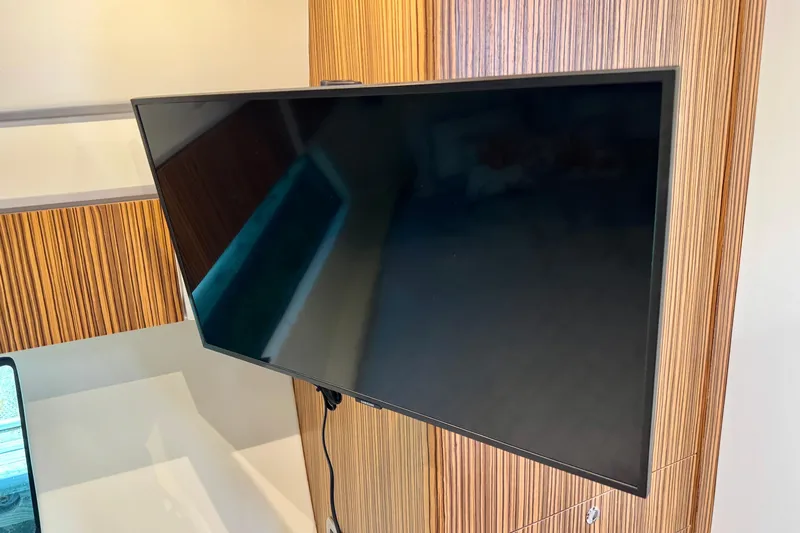 Slide: The Image of Wall-mounted TV in a modern interior, featuring wood paneling on an Intrepid 50 Evolution, 2025. - 32