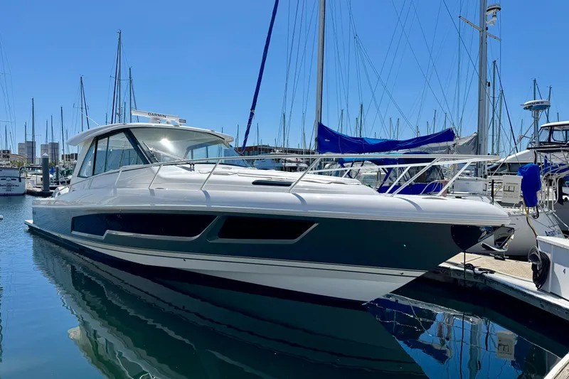 Slide: The Image of 2025 Intrepid 50 Evolution yacht docked in a marina under clear blue skies. - 38