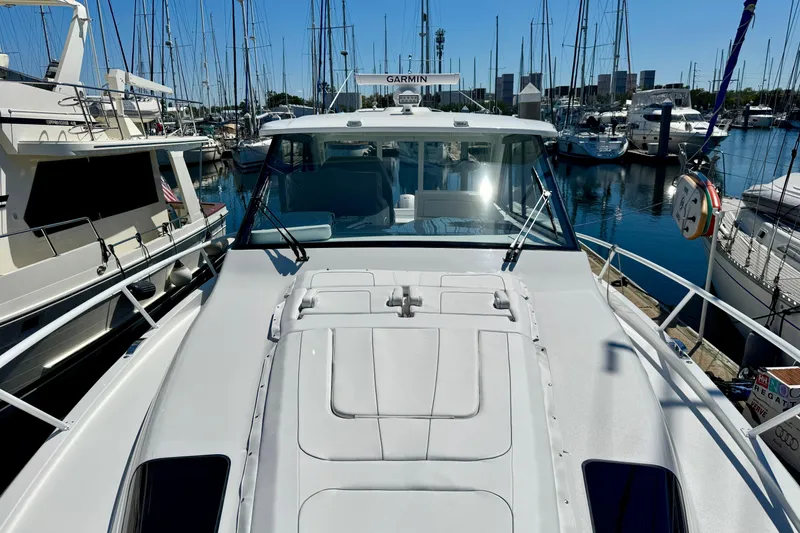 Slide: The Image of 2025 Intrepid 50 Evolution yacht docked in a marina, surrounded by sailboats. - 43