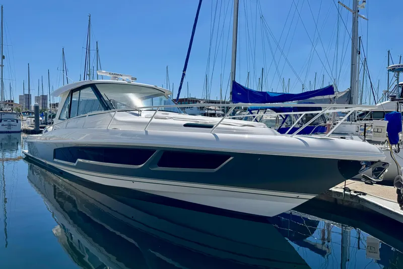Slide: The Image of 2025 Intrepid 50 Evolution yacht docked in a marina under clear blue skies. - 46