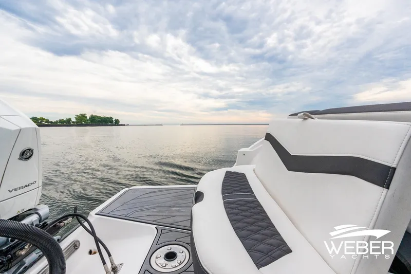Slide: The Image of 2023 Monterey 255SS Super Sport boat on calm water, featuring luxurious seating and Verado engine. - 18