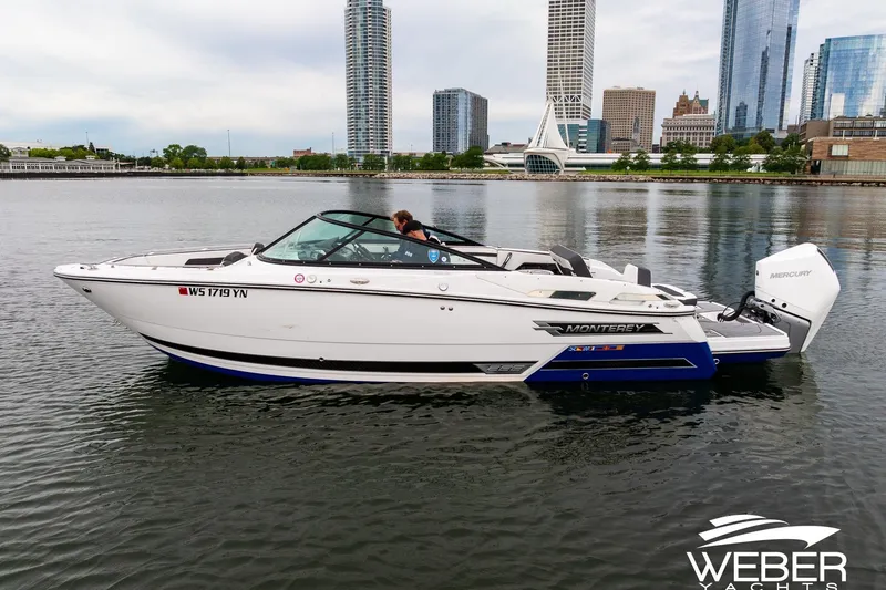 Slide: The Image of 2023 Monterey 255SS Super Sport boat on calm water with city skyline backdrop. - 7