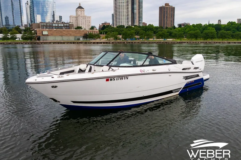 Slide: The Image of 2023 Monterey 255SS Super Sport boat on calm water with city skyline backdrop. - 6