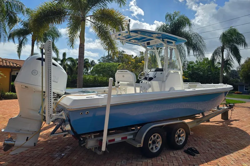 Slide: The Image of 2014 Everglades 243 Center Console boat on trailer, parked under palm trees. - 3