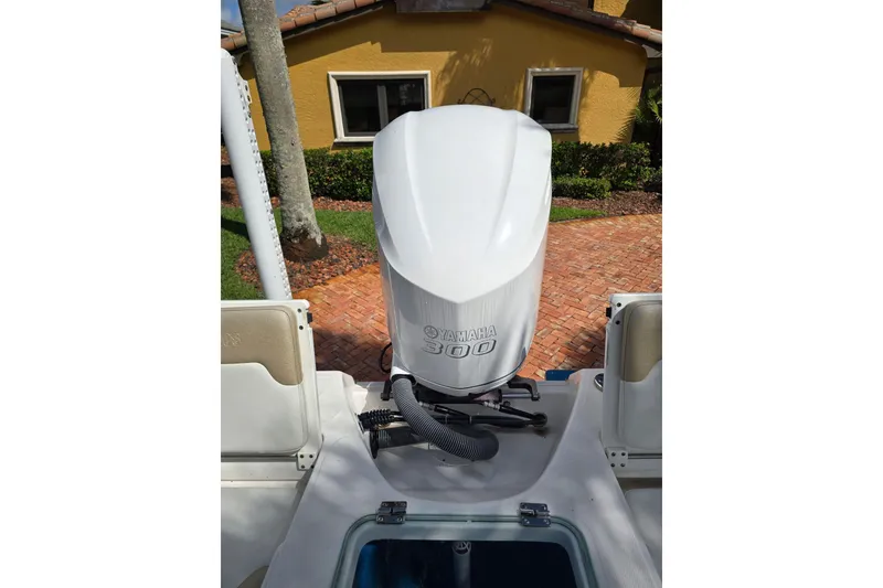 Slide: The Image of 2014 Everglades 243 Center Console with Yamaha 300 engine, parked near a yellow house. - 8
