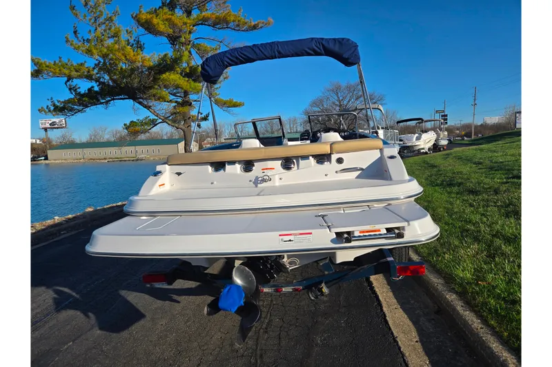 Slide: The Image of 2016 Glastron GT 185 boat on trailer by a lakeside road. - 2