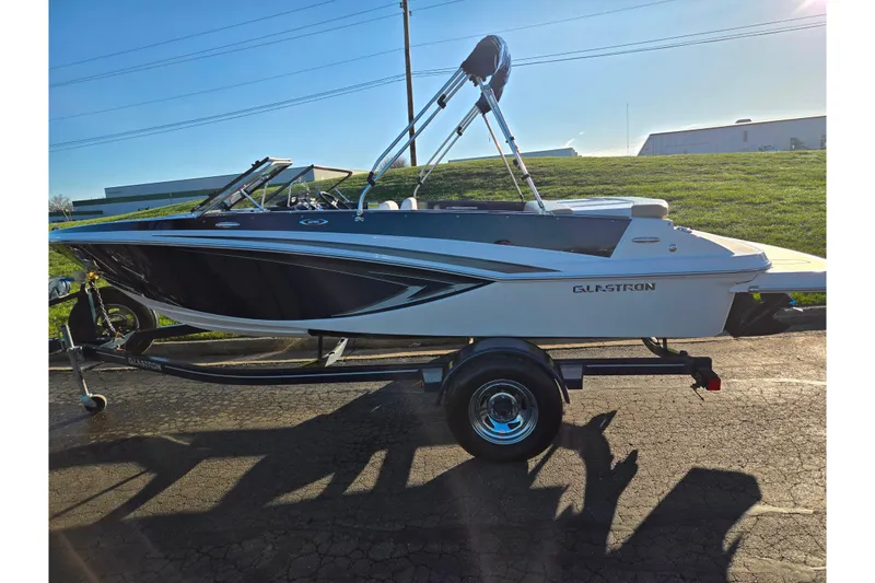 Slide: The Image of 2016 Glastron GT 185 boat on trailer, parked outdoors under clear sky. - 4
