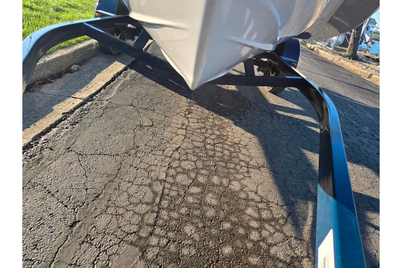 Slide: The Image of 2016 Glastron GT 185 boat on trailer, parked on cracked asphalt road. - 7