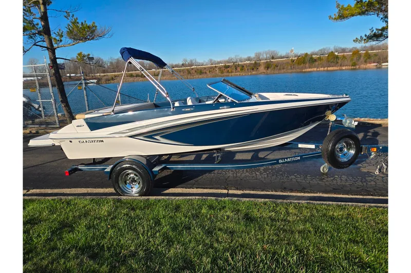 Slide: The Image of 2016 Glastron GT 185 boat on trailer by a lakeside, under clear blue sky. - 9