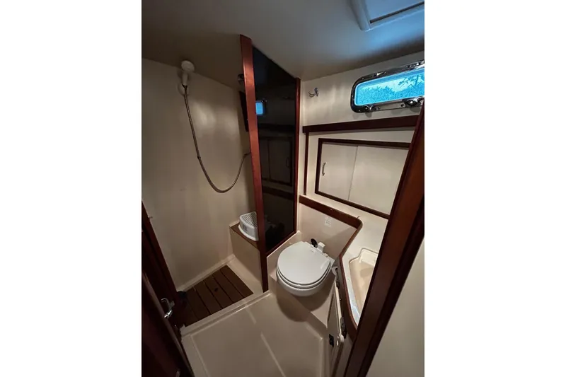 Slide: The Image of Bathroom interior of a 2001 Sabre 34 yacht, featuring a compact design with wooden accents. - 12