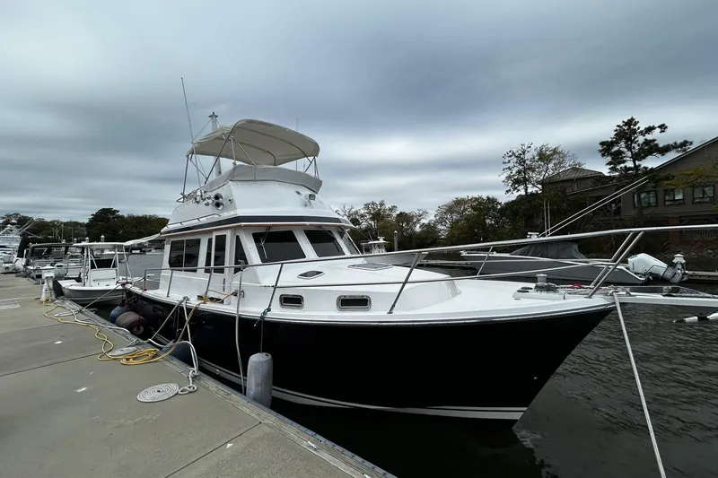 Slide: The Image of 2001 Sabre 34 yacht docked at marina under cloudy sky. - 2