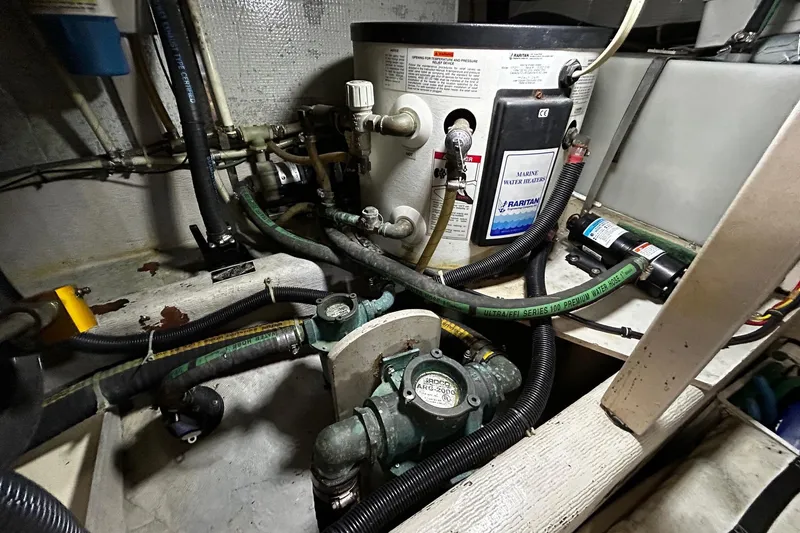 Slide: The Image of Engine room of a 2001 Sabre 34 boat featuring marine water heater and plumbing components. - 27