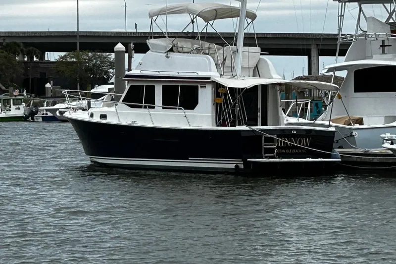 Slide: The Image of 2001 Sabre 34 boat docked in a marina, featuring a sleek design and canopy. - 4