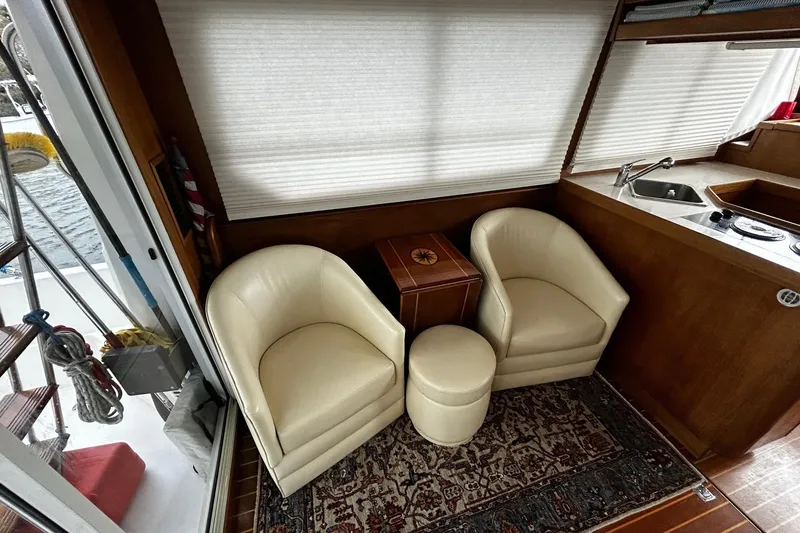 Slide: The Image of Interior of a 2001 Sabre 34 yacht with cream chairs and a compact kitchenette. - 8
