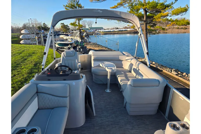Slide: The Image of 2021 Bennington S 20 L-Bench pontoon boat docked by a serene lake. - 11