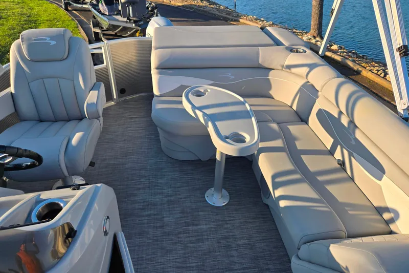 Slide: The Image of 2021 Bennington S 20 L-Bench pontoon boat interior with plush seating and table. - 13