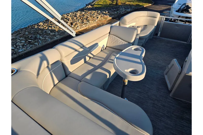 Slide: The Image of 2021 Bennington S 20 L-Bench pontoon boat interior with plush seating and table. - 19