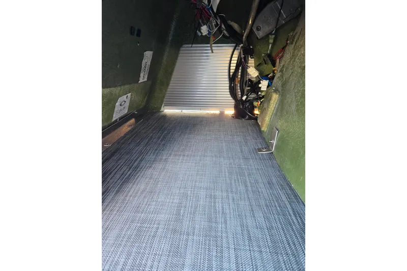 Slide: The Image of Interior view of a 2021 Bennington S 20 L-Bench boat, showcasing wiring and flooring. - 22