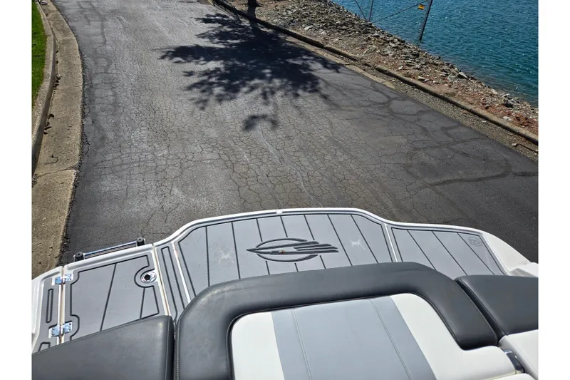 Slide: The Image of 2024 Chaparral 21 SSi boat on a paved road near a lake. - 17