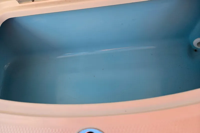 Slide: The Image of Livewell compartment in 2024 Chaparral 21 SSi boat, featuring a clean blue interior. - 21