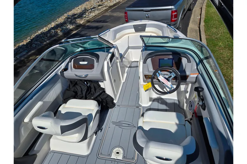 Slide: The Image of 2024 Chaparral 21 SSi boat interior with modern dashboard and seating near water. - 3