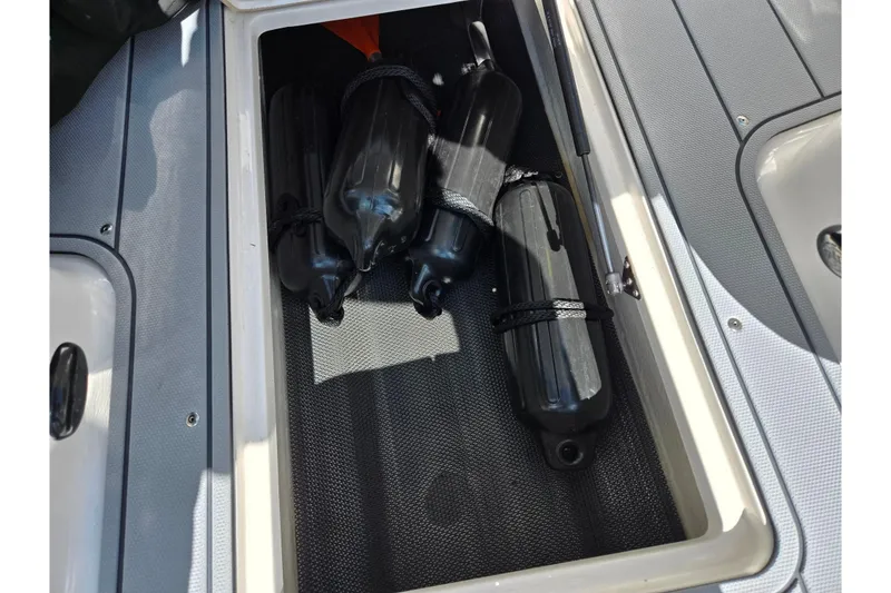 Slide: The Image of Storage compartment with black fenders on a 2024 Chaparral 21 SSi boat. - 5