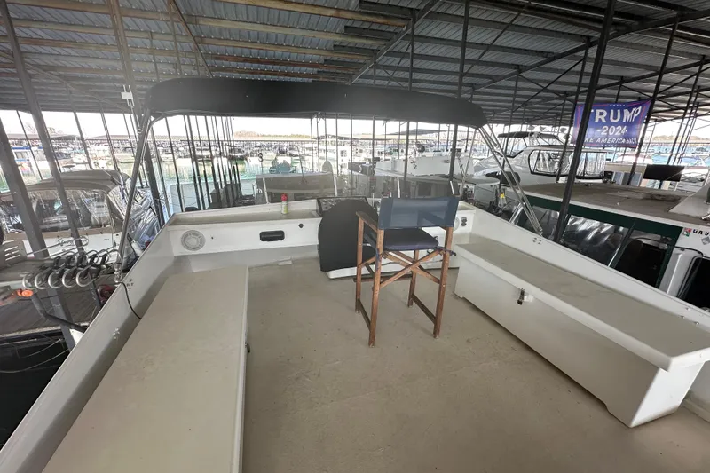 Slide: The Image of 1974 Lazy Days 14x56 boat interior with seating and canopy in a marina. - 14