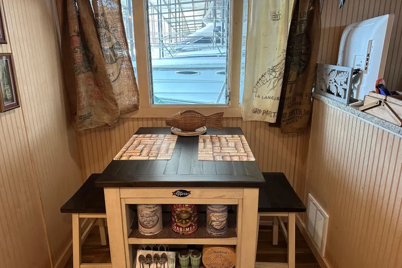 Slide: The Image of Cozy dining nook in a 1974 Lazy Days houseboat with nautical decor and rustic curtains. - 5