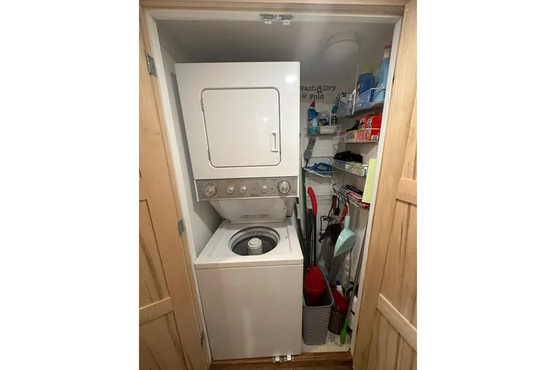 Slide: The Image of Compact laundry area with stacked washer-dryer, shelves, and cleaning supplies in a 1974 Lazy Days model. - 8