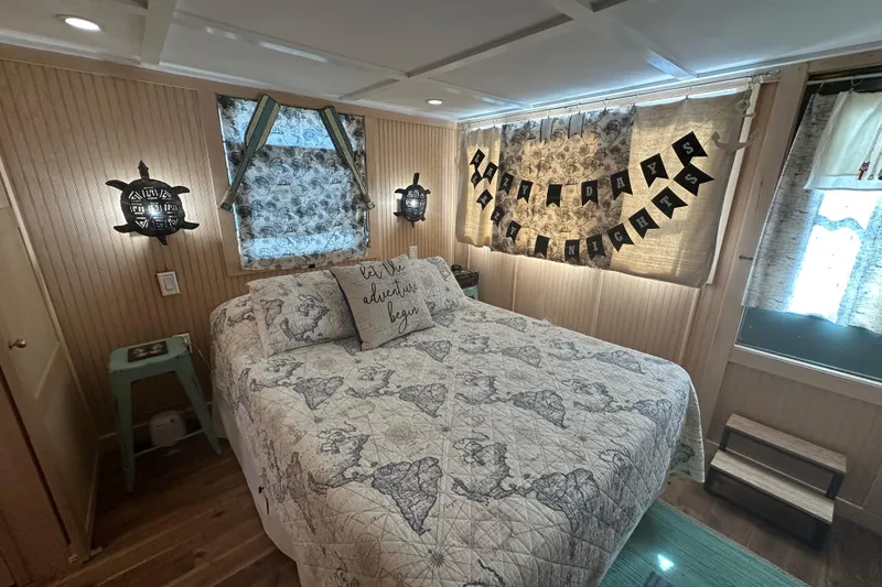 Slide: The Image of Cozy bedroom in 1974 Lazy Days model, featuring nautical decor and map-themed bedding. - 9