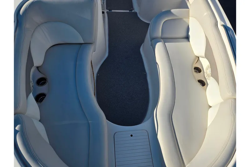 Slide: The Image of 2005 Chaparral Sunesta 232 boat interior with white cushioned seating and cup holders. - 20