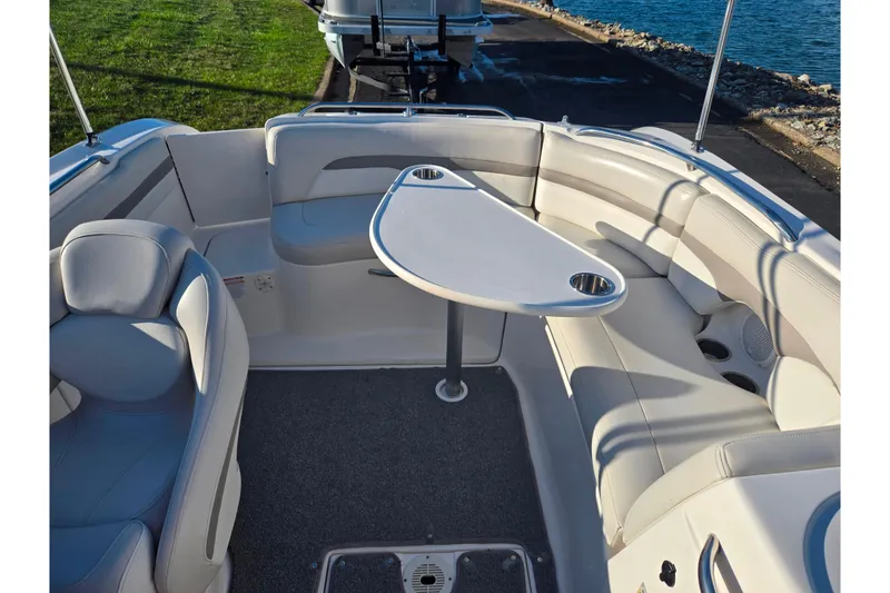 Slide: The Image of 2005 Chaparral Sunesta 232 boat interior with seating and table, near water. - 24