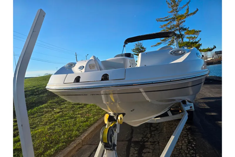 Slide: The Image of 2005 Chaparral Sunesta 232 boat on trailer, parked near water and grassy area. - 6